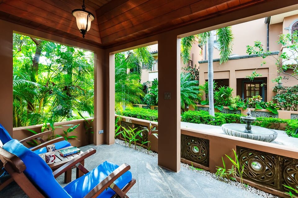 Front-side porch at the Langosta Beach villa in Tamarindo, featuring cozy seating and views of the lush courtyard garden. Enjoy the tropical Costa Rica nature and a serene luxury villa experience.