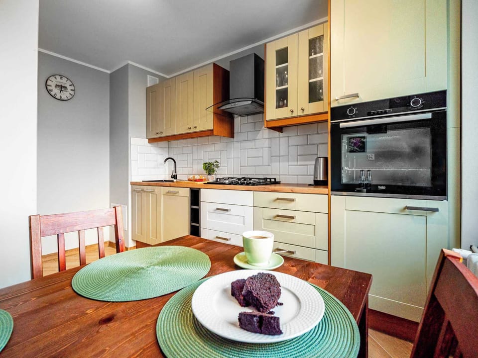 A compact kitchen and dining area with a wooden table set for breakfast, blending functionality and charm.
