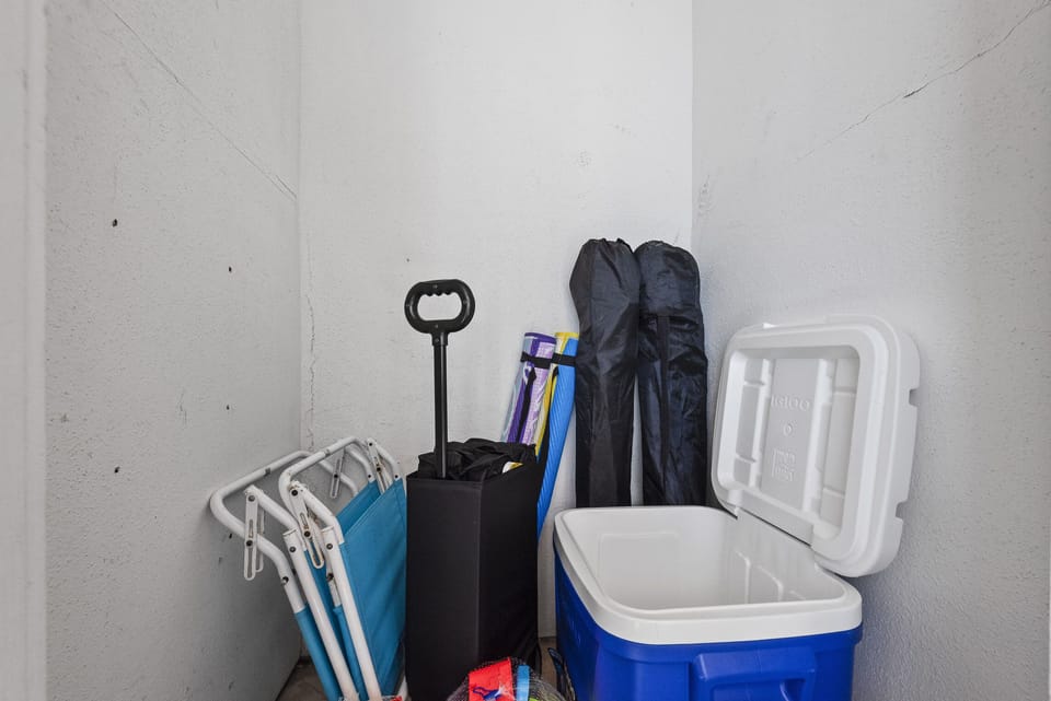 Outside storage contains beach wagon, chairs, and cooler.