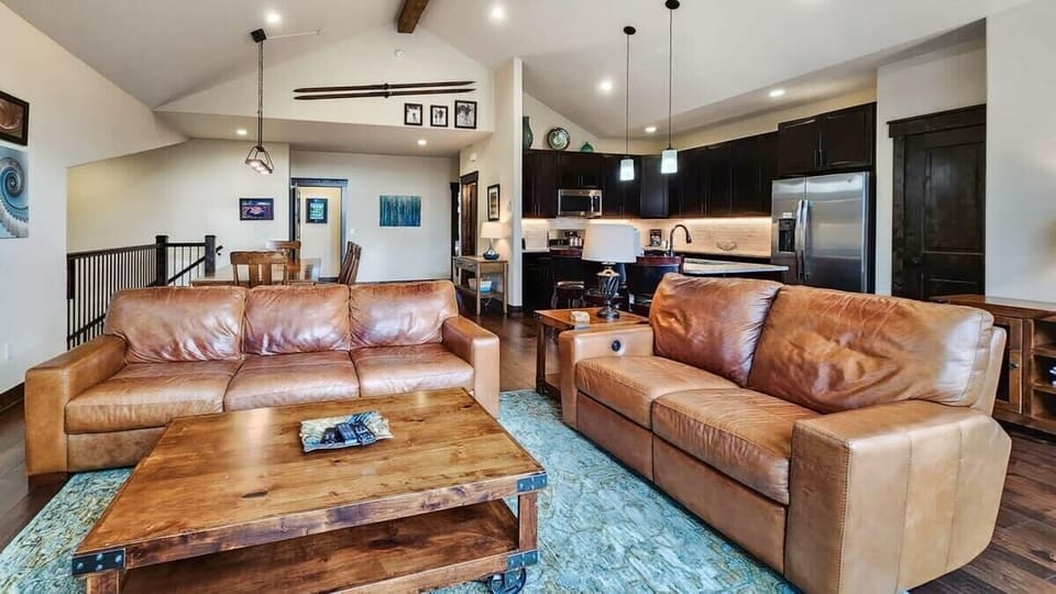 The inviting living room features a 3-person couch, a reclining loveseat, a gas fireplace, and views over the surrounding mountains.