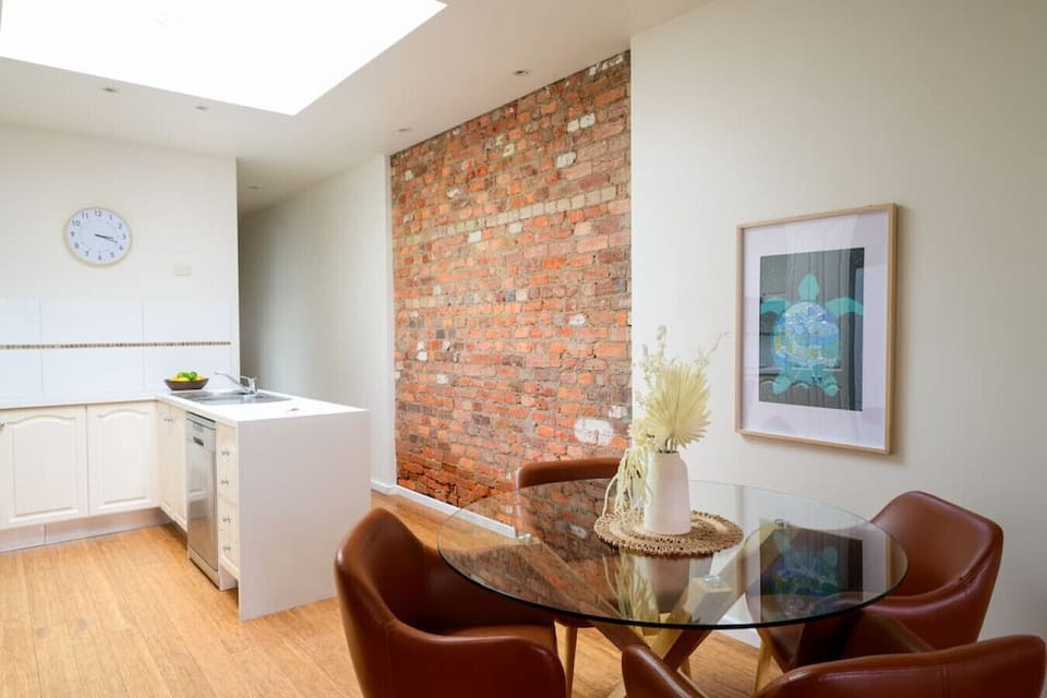 An open-plan dining room leads to a kitchen that has a dining table that seats 4.