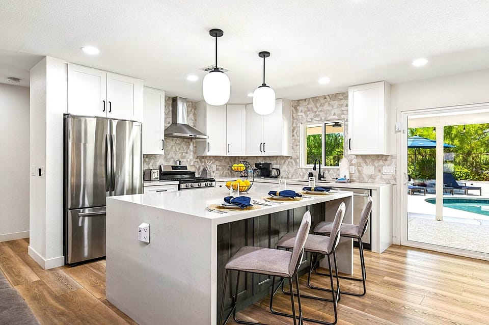 Gourmet kitchen with quartz island, gas range, RO drinking tap, pool sightline.