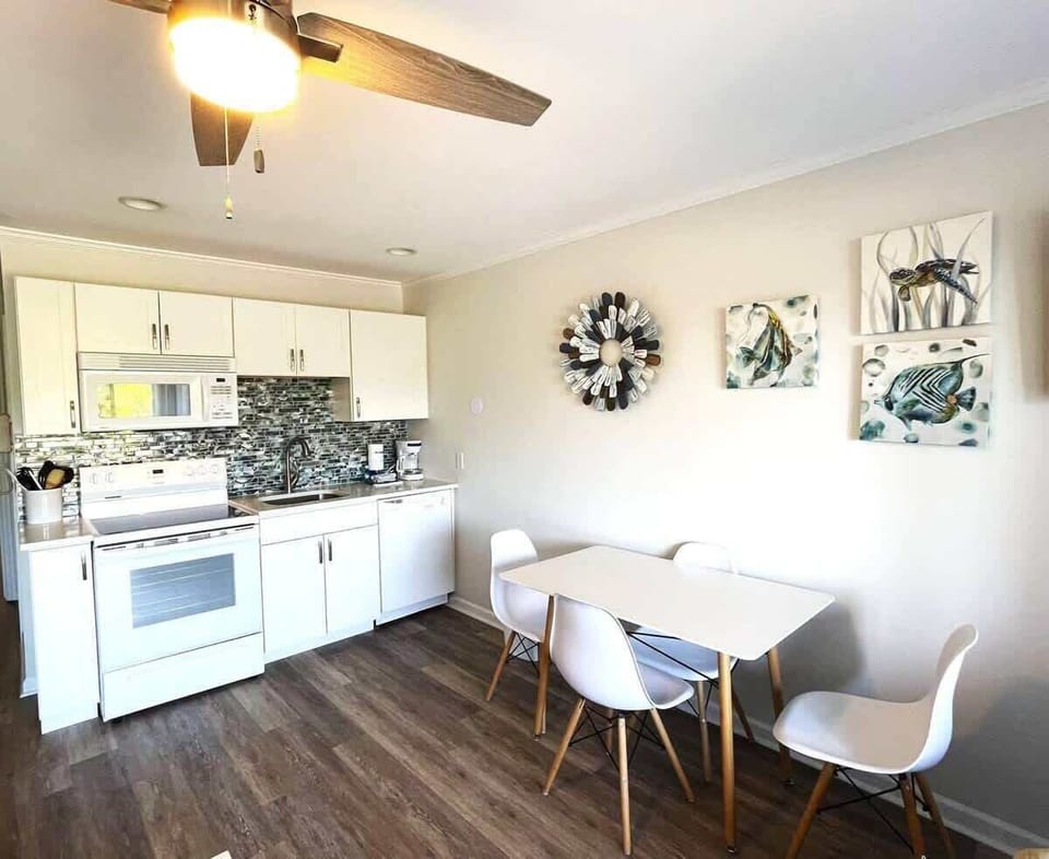 A sleek white table with three mid-century modern chairs sits against the wall.