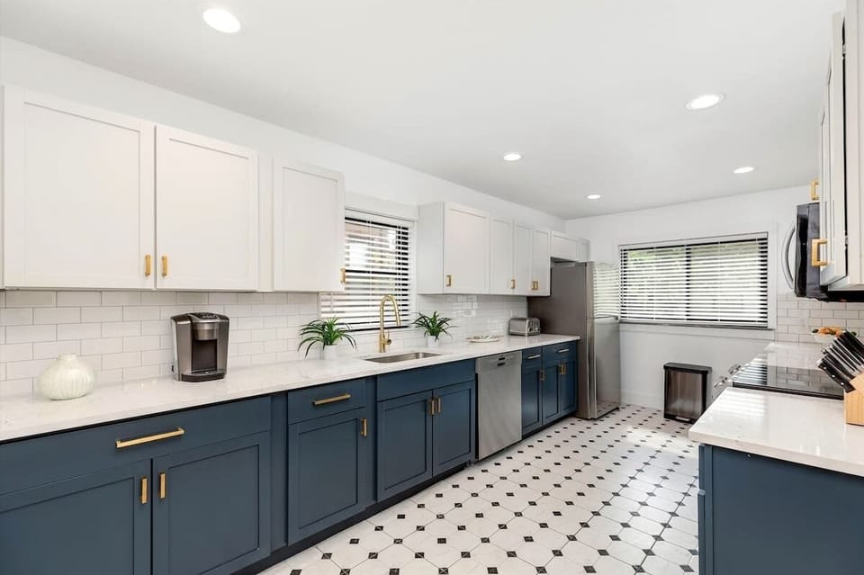 Stylish kitchen with navy cabinets and gold accents.
