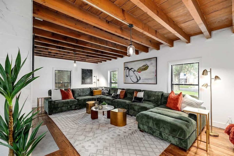 Spacious living room with exposed wood beams and large sectional.