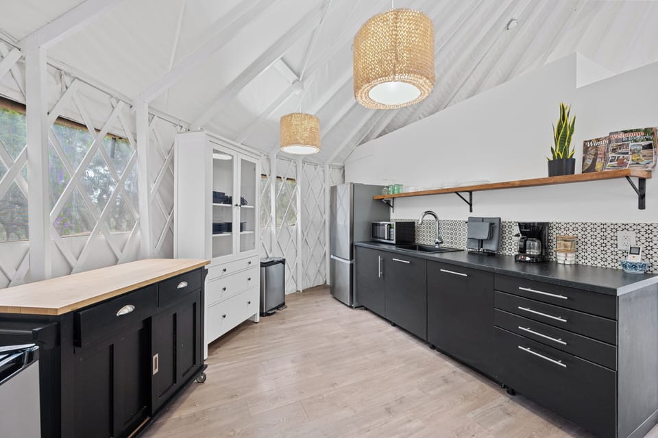 Kitchen with coffee maker, refrigerator with a small freezer and a microwave.