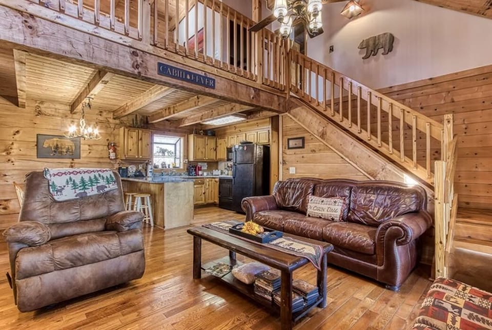 Spacious living room that is open to the kitchen and stairs leading upstairs to secondary living spaces at A Place in Time.