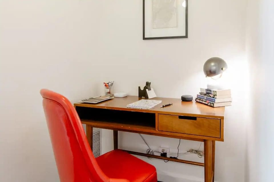 Welcome to our cozy home office on the 3rd floor. 🏡🖥️ This inviting space features a vibrant red chair, a perfectly coordinating rug, and a functional desk. Nestled between the recently mentioned bathroom and the bedroom, it's a convenient spot for work or study. Create your own productive haven in this comfortable corner of the house. 🪴📚