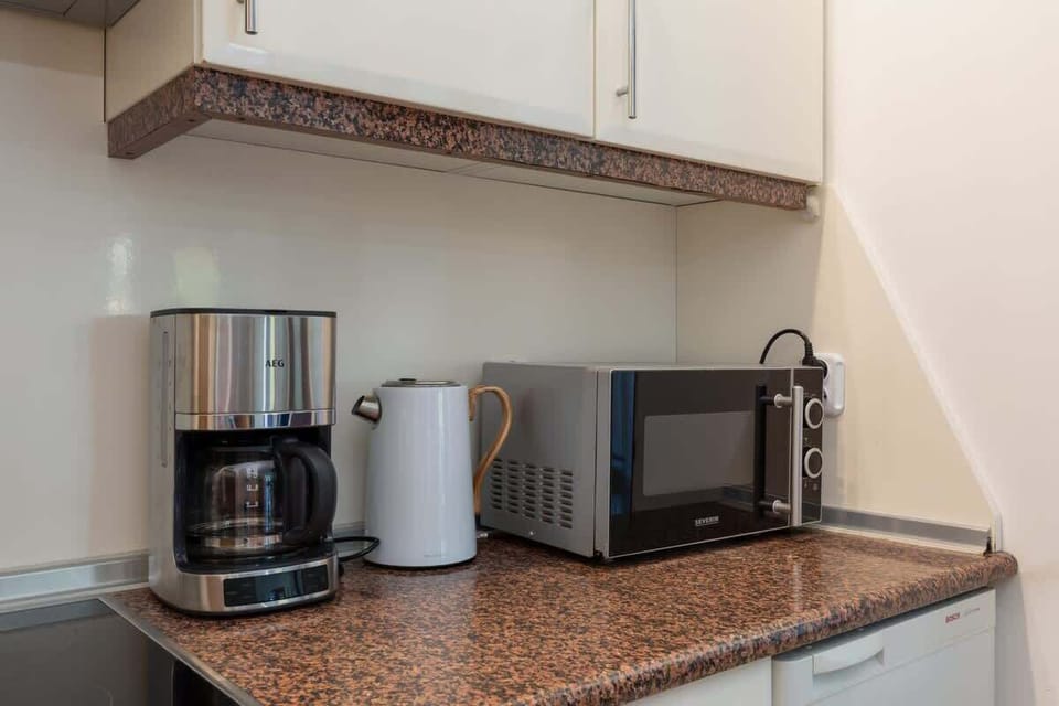 A close-up of the kitchen countertop featuring a coffee maker, toaster, and microwave for added convenience.
