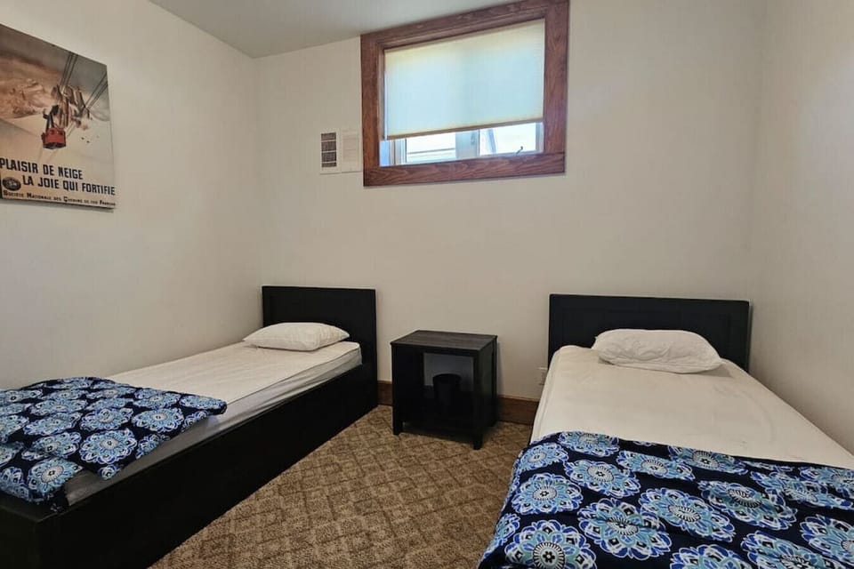 Main floor bedroom w/ 2 single beds w/ closet and att bathroom