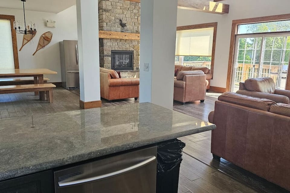 Looking over the kitchen island into the side of the main living area with the fireplace