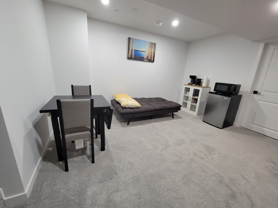 living room showing dining table, sofa bed style, mini fridge and microwave