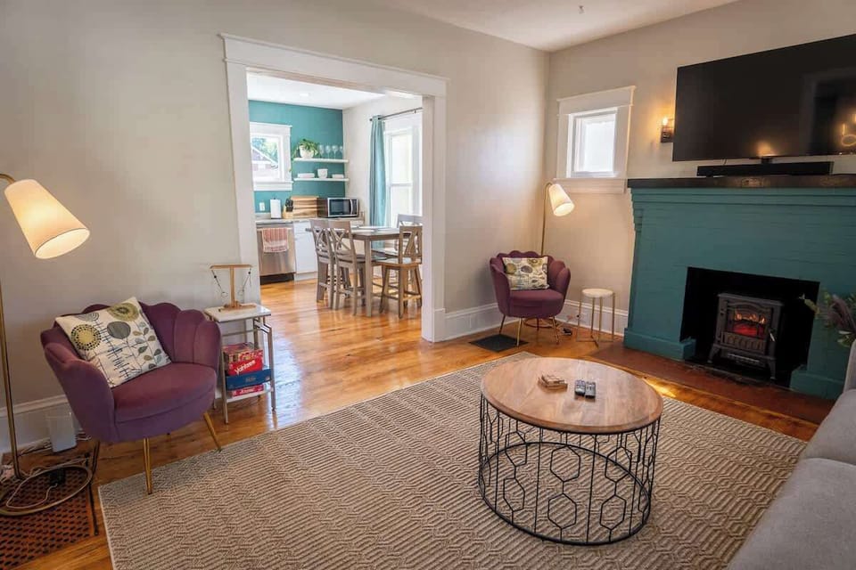 Cozy up by the fireplace in this living room, where a circular table adds a touch of elegance and encourages intimate conversations.