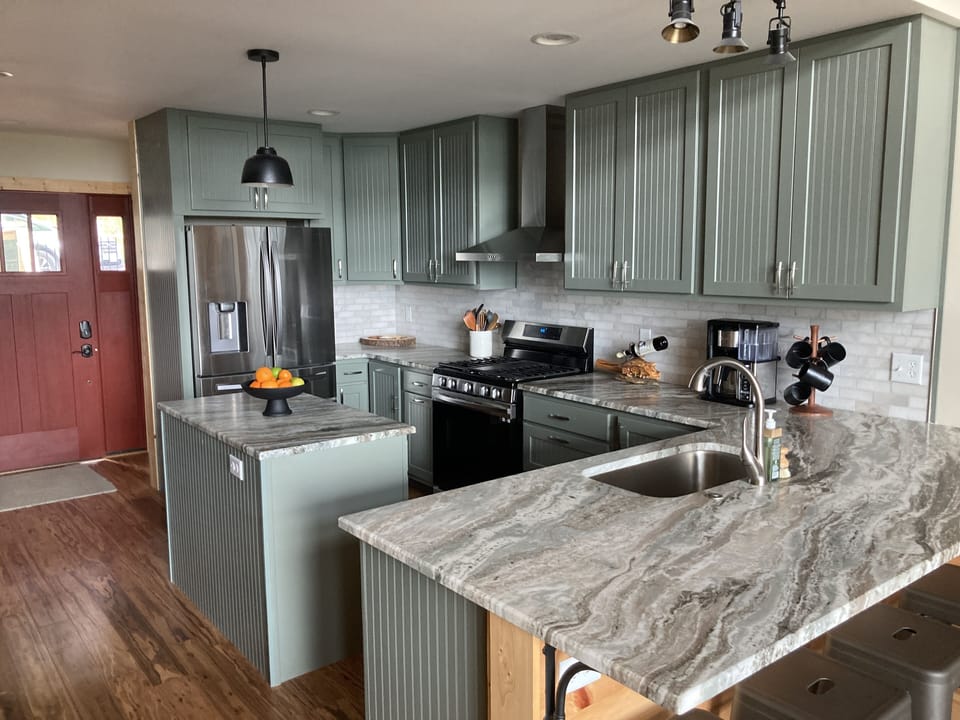 Bright kitchen with sleek cabinets, granite counters, and island seating.