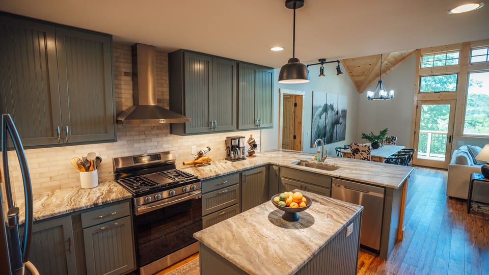 Modern kitchen with stainless steel appliances and granite countertops.