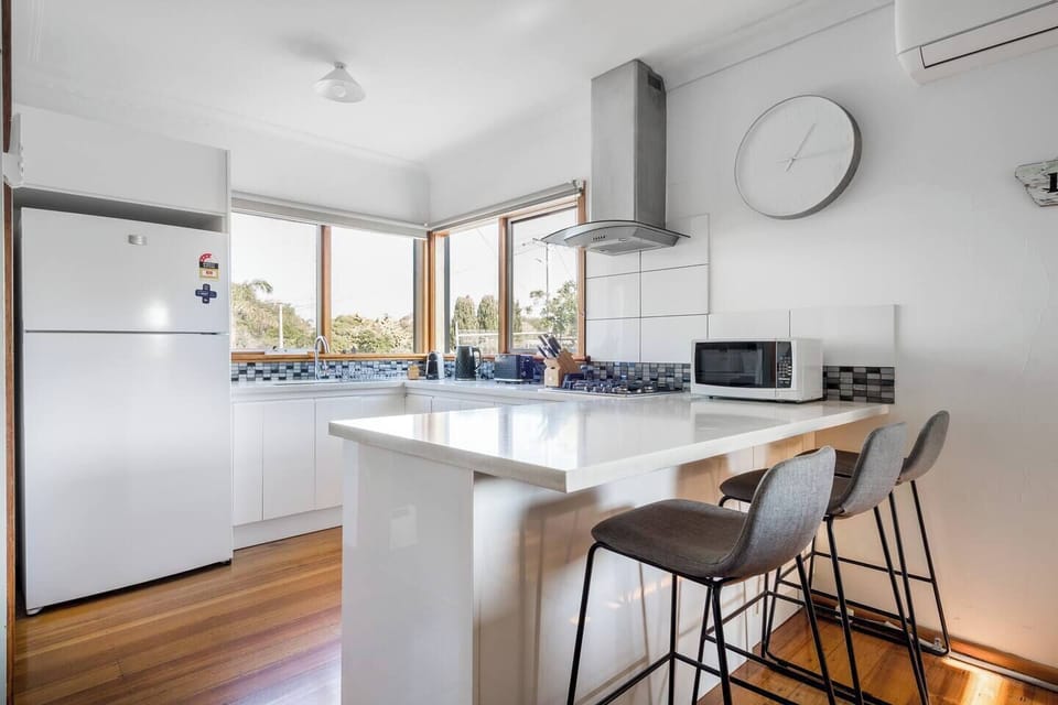 A tidy, well-equipped kitchen features all the essentials for cooking at home, along with a breakfast bar that provides additional seating.