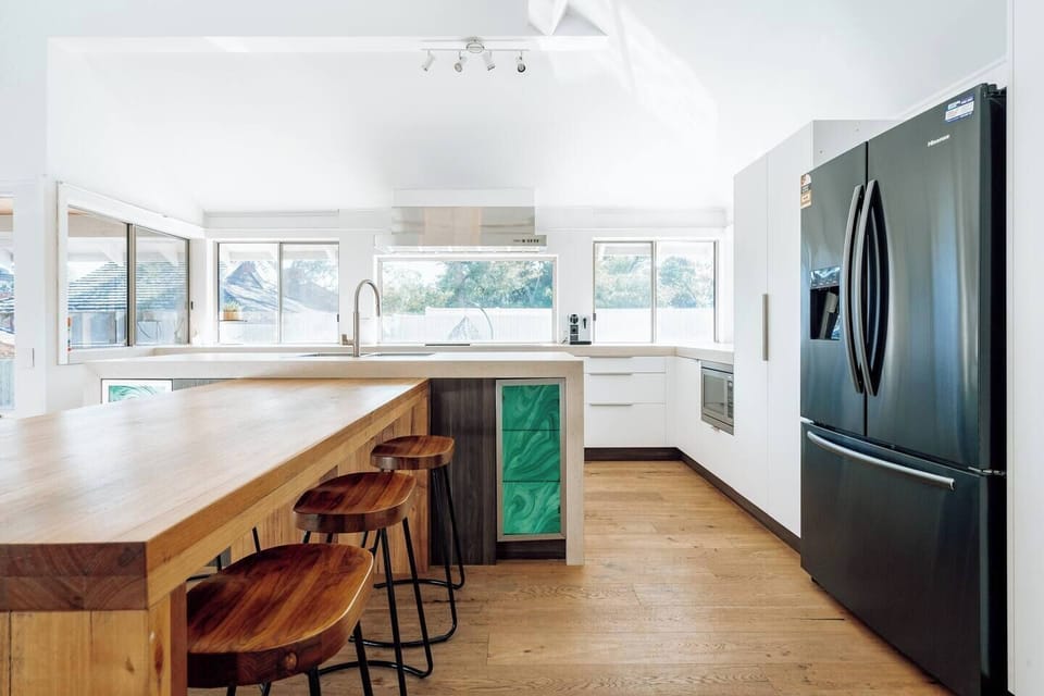 The full kitchen, complete with modern stools, is a hub of culinary inspiration.