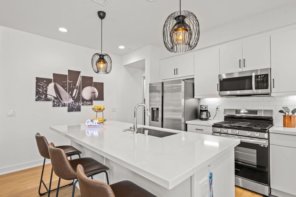 Cook & gather in the sleek white kitchen w/ large island & bar seating.