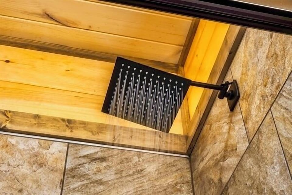 Let the warm cascade of the rainfall shower wash over you, surrounded by the cozy glow of cabin wood a moment of pure mountain luxury.