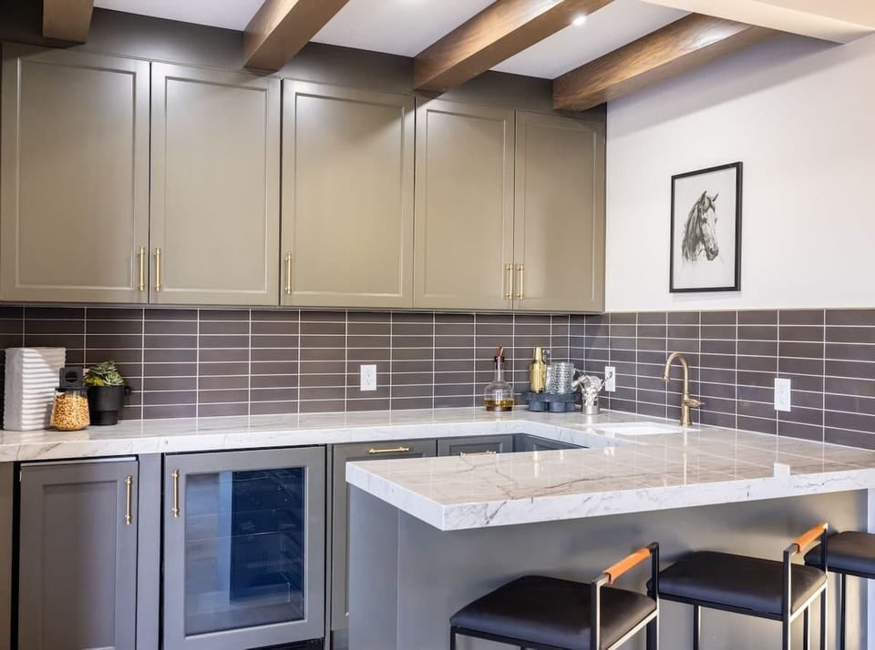 Chic wet bar with marble countertops and designer cabinetry—ideal for entertaining with style.