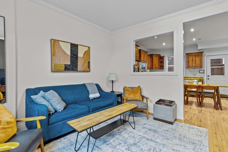 The warm and inviting living room is centered around a plush, comfortable couch that beckons relaxation.  The room is spacious, with plenty of natural light streaming in through the windows, further enhancing the inviting atmosphere. 