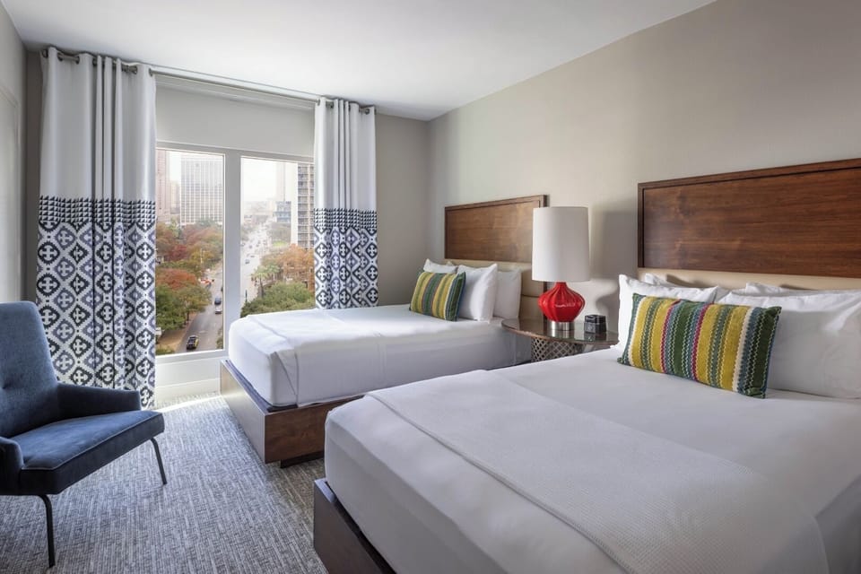 Recharge in a crisp king bed with warm bedside glow.