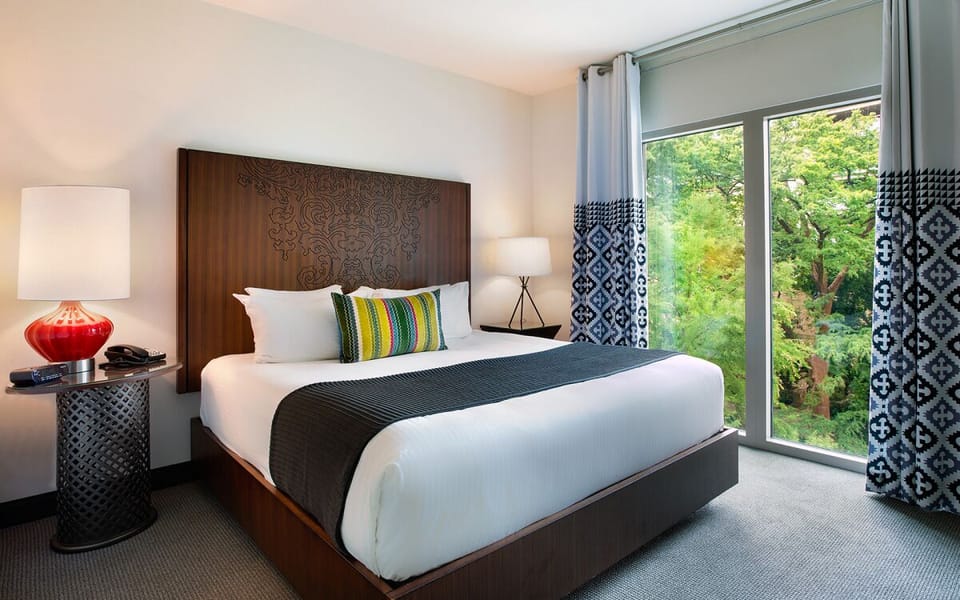 Unwind in a bright bedroom with serene treetop views.