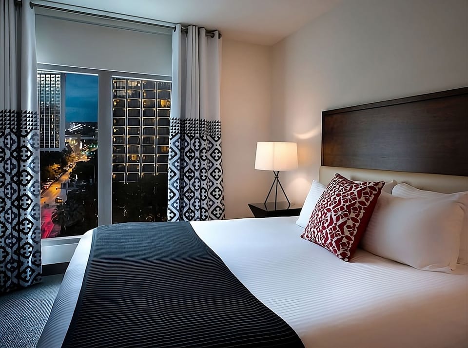 Drift off beside sparkling city lights through tall windows.