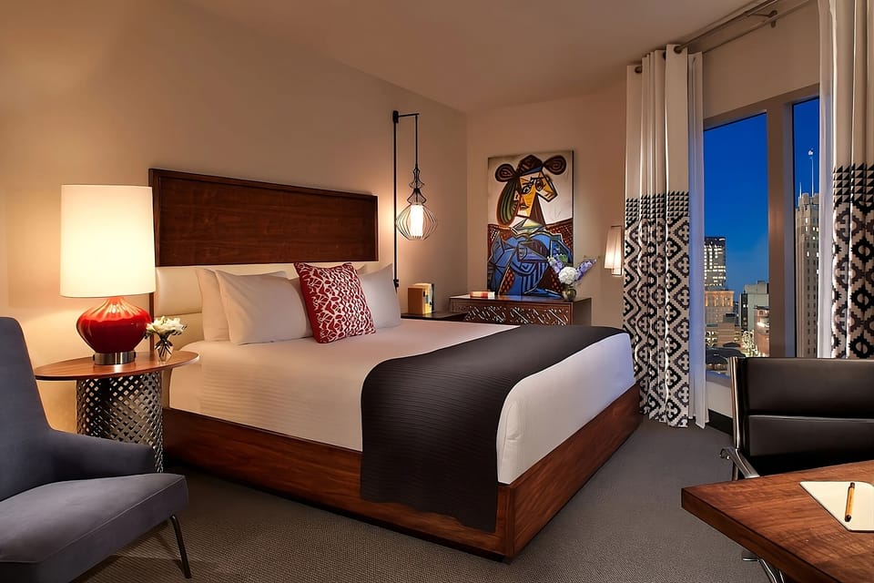 Unwind in a plush king bed with sparkling city views.