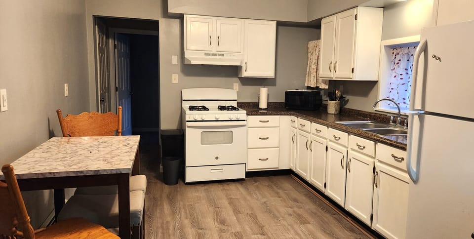 Full size gas range with oven. Table with 2 swivel stools and 2 padded stools