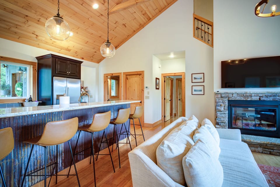 Kitchen island w/ view of doors to half bath, kitchen pantry and master bedroom.