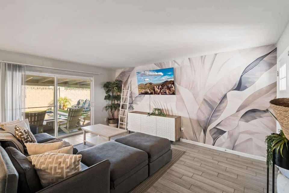 Relax in this stylish living space with modern decor and artistic flair. Sink into the plush sectional, enjoy natural light streaming through sliding doors, and step onto your private patio for outdoor lounging.
