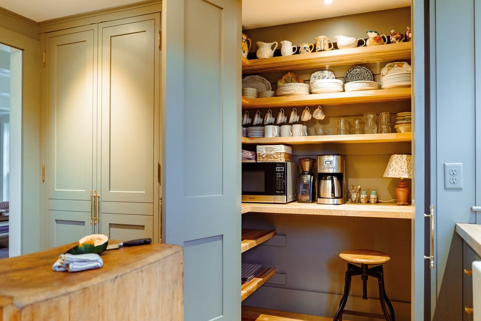 Built-in cupboards hold the microwave, burr grinder, coffee maker, and dishes.
