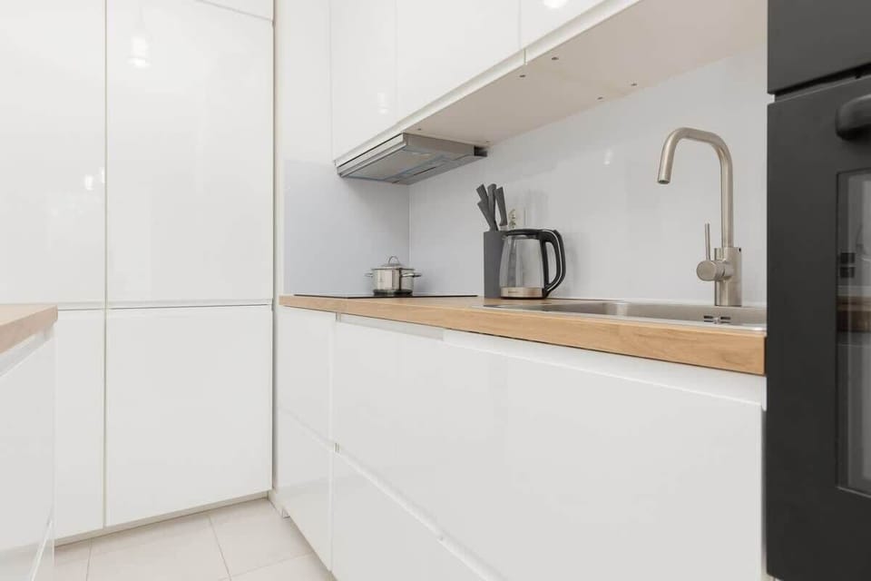 A detailed look at the kitchen corner with a kettle, coffee machine, and wooden countertop, offering convenience and style.
