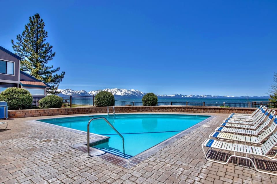 Stunning outdoor pool with magnificent snow-capped mountain backdrop and crystal-clear blue waters.