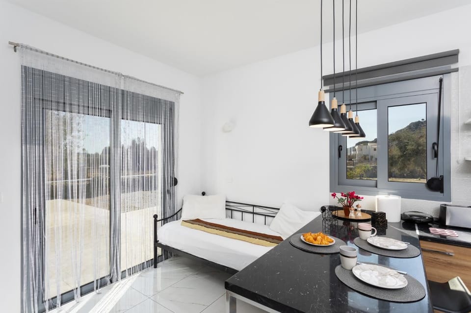 Open-plan living room with sofa, dining area, kitchen, A/C, WiFi internet, and satellite TV