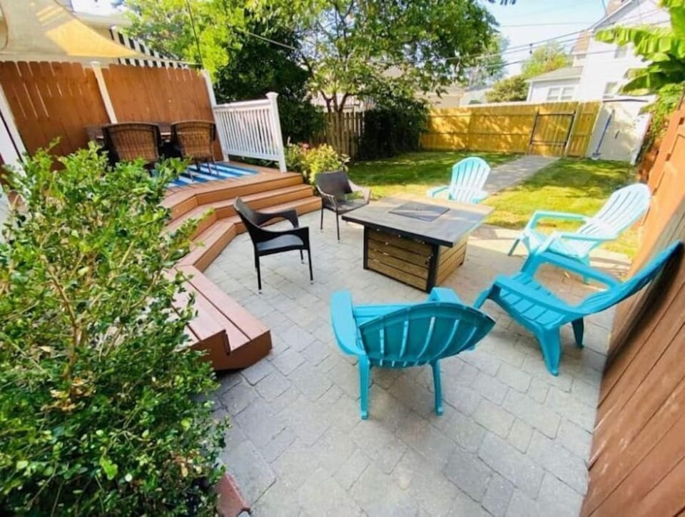 Rear deck and paver patio including firepit and fenced in yard.