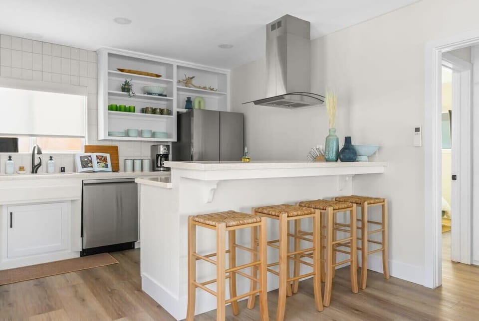 The kitchen island with bar stools provides the perfect spot for a quick bite or a casual conversation while cooking.