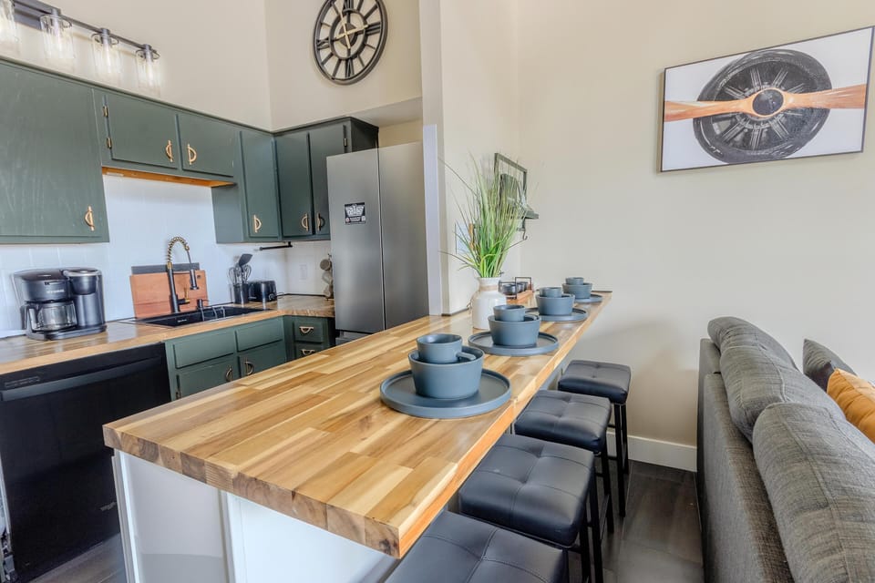The modern kitchen boasts butcher block countertops, a deep gourmet sink, a Keurig and drip-style coffee station, and a central island perfect for shared meals.