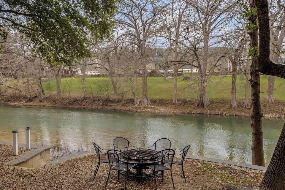 Scenic river view from the yard with mature trees and open space—perfect for picnics and quiet outdoor moments.