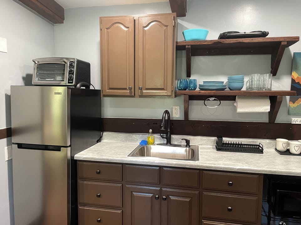 Kitchenette with fridge, toaster oven, & hot pad. 
