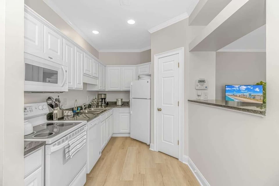 Step into this spacious kitchen, where modern finishes and plenty of counter space make it perfect for preparing meals, enjoying a morning coffee, or grabbing a snack between beach trips. - The Myrtle - Myrtle Beach, SC