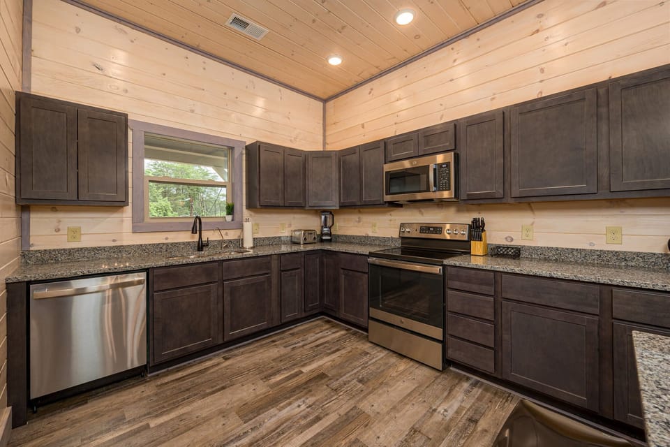 Cook gourmet meals in our fully-equipped kitchen with modern appliances and ample counter space, ideal for culinary enthusiasts. - The Smokey - Sevierville, TN