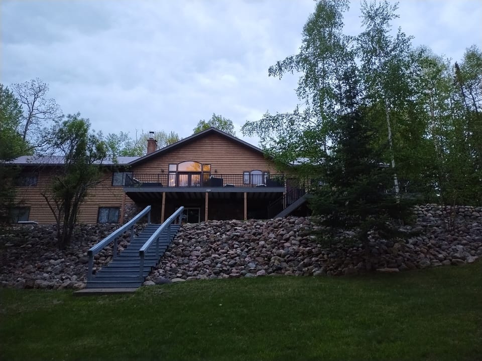 Back of lake home with steps leading down to lake front