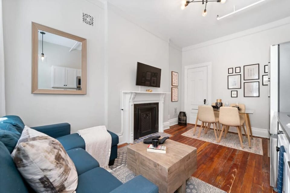 The living room features a comfortable sofa and a smart TV for entertainment.