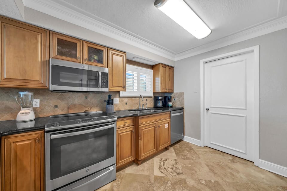 Cook your favorite meals in this fully equipped kitchen with granite counters, stainless appliances, and warm wood cabinetry.