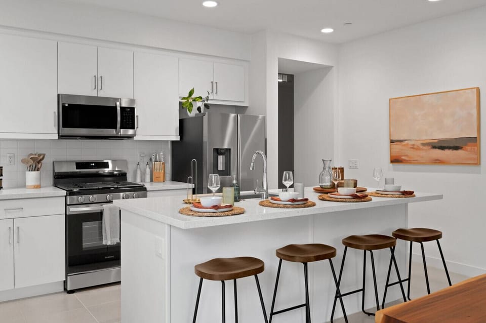 Sleek kitchen w/ large island seating, stainless appliances & clean modern finishes