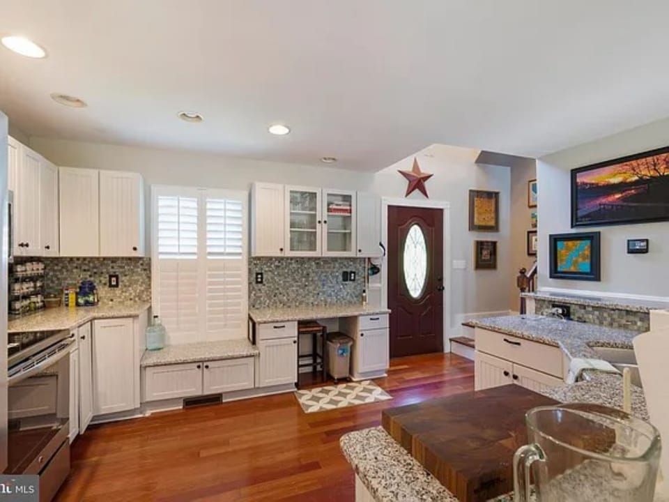Stocked kitchen with dishes, glassware, utensils, pots and pans.