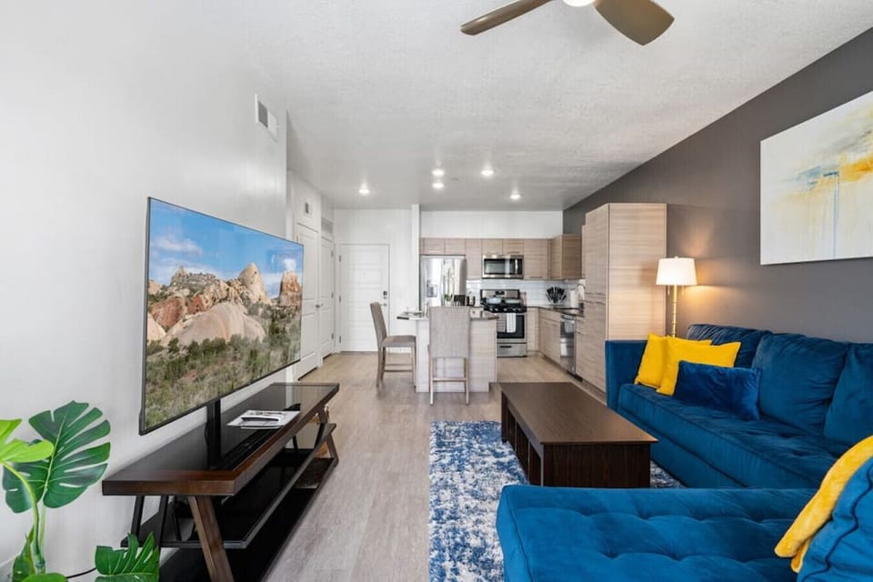 Beautifully designed living room. 65` Roku TV, colorful sectional sofa and amazing views of mountains and city skyline.