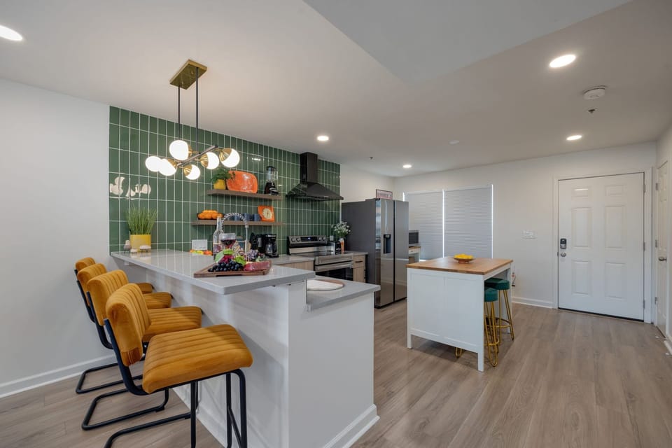 (1st Floor) Fully equipped kitchen with stainless steel appliances, basic cooking essentials, and kitchen island seating.